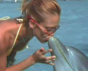 Actress Jessica Alba kissing a Dolphin